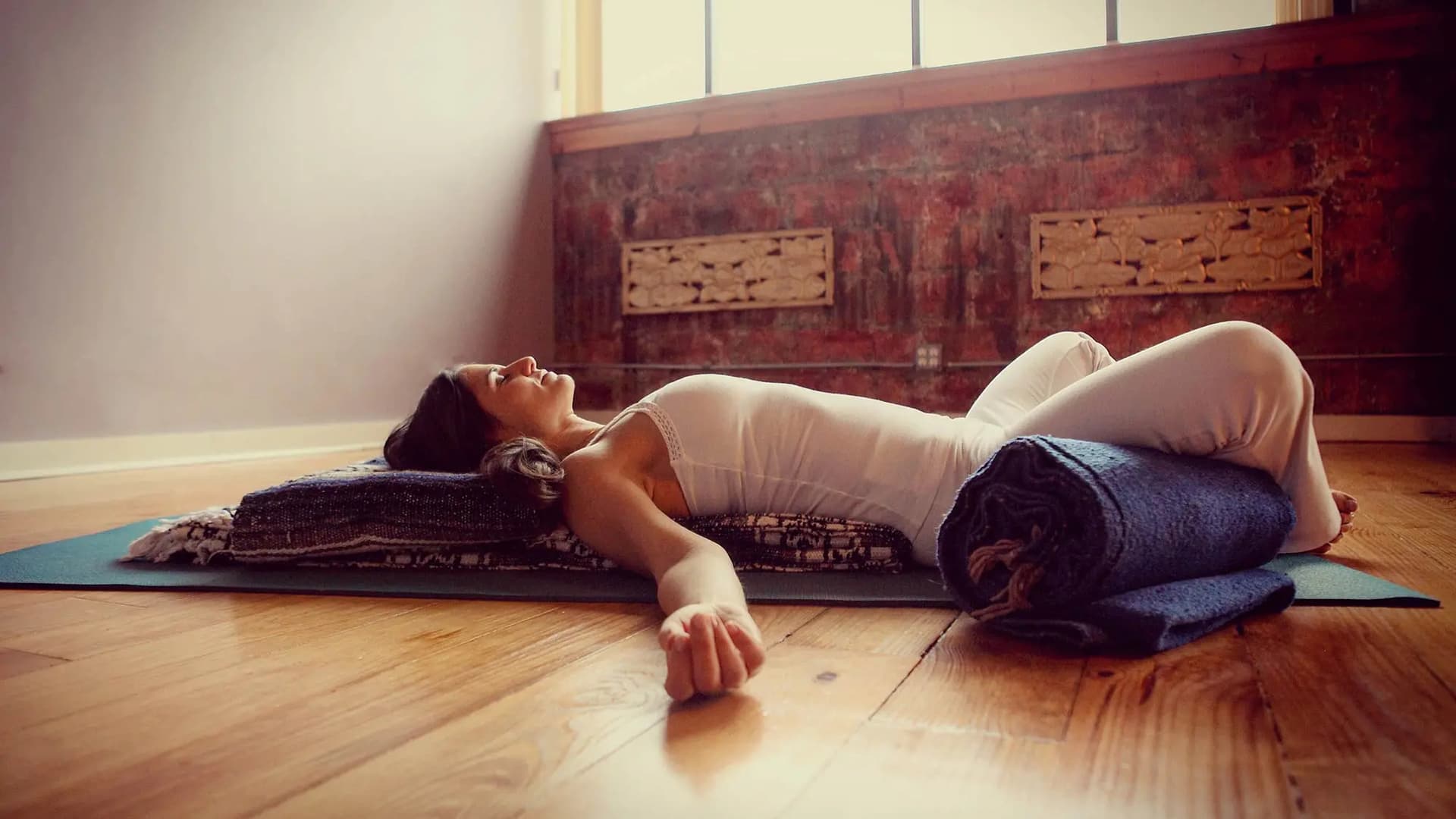 Restorative Yoga, kvinna som ligger på rygg på en yogamatta
